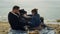 Family laughing enjoying beach together on sea vacation. Parents tickle child.