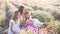 Family in lavender flowers field at sunset in white dress and hat