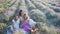 Family in lavender flowers field at sunset in white dress and hat