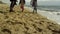 Family legs play beach together at sea shore. Fun people walking by ocean waves.