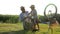 Family leisure, kid and father repairing bicycle at rural on background of nature in backlight