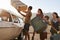 Family Loading Luggage Onto Car Roof Rack Ready For Road Trip