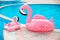 Family look. Two Pink pool floats flamingo by blue water, pool party toy. Giant Inflatable Swimming Ring. Summer vacation holiday