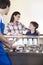 Family Looking At Each Other While Waiter Preparing Ice Cream