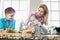 Family looking at girl mixing salad in kitchen