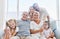 Family, love and children with a girl, parents and grandparents sitting on a living room sofa at home together. Kids