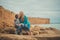 Family lovely scene of beautyful mother posing kissing her cute handsome son on beach sea side during summer vacation on ocean res