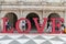 Family in Macau, LOVE letters posing outdoors large lettering red fun and travel