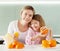 Family make orange juice on a juicer