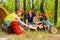 Family making camp fire with fireplace log pieces