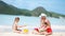 Family making sand castle at tropical white beach.