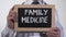 Family medicine text on blackboard in physician hands, comprehensive healthcare