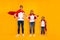 Family members playing cartoon incredible characters wear superhero flying coats isolated yellow background