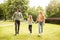 Family members walking in the park wearing fabric face masks. Father, mother and daughter protect themselves from the virus