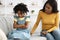 Family Misunderstanding. Offended black girl sitting on couch after quarrel with mom