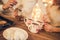 Family: mom, dad and daughter in white sweaters cook and drink cocoa with marshmallows. Closeup hands and cups. Christmas concept