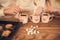 Family: mom, dad and daughter in white sweaters cook and drink cocoa with marshmallows. Closeup hands and cups. Christmas concept