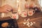 Family: mom, dad and daughter in white sweaters cook and drink cocoa with marshmallows. Closeup hands and cups. Christmas concept