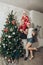 Family mom, dad and son in Santa costume fool around and play near the Christmas tree in their apartment