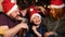 Family - mom, dad and young son are sitting in New Year`s hats and having fun on the holidays