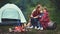 Family mother and child daughter warm their hands by bonfire on