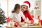 Family mother and child rolling the dough, bake christmas cookies in festival decorated room