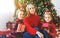 Family mother and children open presents on Christmas morning