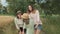 Family mother and children two daughters walking together along country road