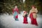 Family with mother, teenage girl, and little daughter dressed in stylized medieval peasant clothing in winter forest