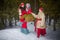 Family with mother, teenage girl, and little daughter dressed in stylized medieval peasant clothing in winter forest