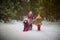 Family with mother, teenage girl, and little daughter dressed in stylized medieval peasant clothing in winter forest