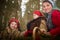 Family with mother, teenage girl, and little daughter dressed in stylized medieval peasant clothing in winter forest