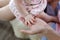 Family, motherhood, parenting, people and child care concept - close up of mother and newborn baby hands