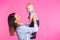 Family, motherhood, parenting, people and child care concept - happy mother holds adorable baby over pink background