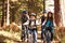 Family mountain biking on forest trail, front view