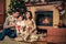 Family near fireplace in Christmas decorated house