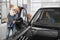 Family observing new automobile in car dealership.