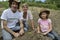 Family of organic farmers planting seedling