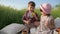 Family outdoors, boy with fields flowers in hand is looking at beautiful girl, two adorable children, boy is looking at