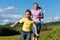 Family outdoors is running on a meadow