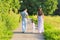 Family, parenthood and people concept - happy mother, father and little girl walking in summer park