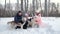 Family Petting and Embracing Sled Dogs on Snow