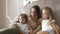 Family With Phone. Woman And Children Using Phone At Bedroom