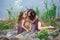 Family photo of mother and child, fauns on the shore of a large lake are sitting on stones, fairy-tale characters, the