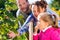 Family picking berries in garden