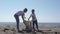 Family picks up trash from the beach in trash bags