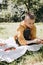 Family picnic. A boy in a green garden in sunny weather on a picnic eating pizza