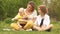 Family picnic, mom with two sons. Kid examines Easter eggs