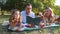 A a family during a picnic in a public park, parents read fairy tales to their children