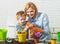 Family planting. Mother and son grow flowers. Child and mother spraying spring flower.